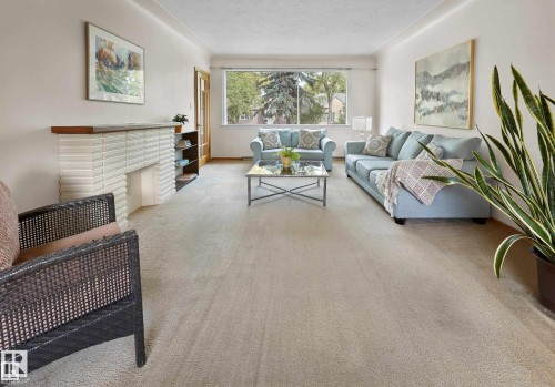 Carpeted living room featuring a textured ceiling - 11127 71 Avenue, Edmonton, AB - Indoor Photo Showing Living Room With Fireplace