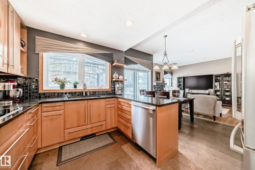 Kitchen with dark stone countertops, open shelves, and a peninsula - 4 Harriott Court, St. Albert, AB - Indoor Photo Showing Kitchen