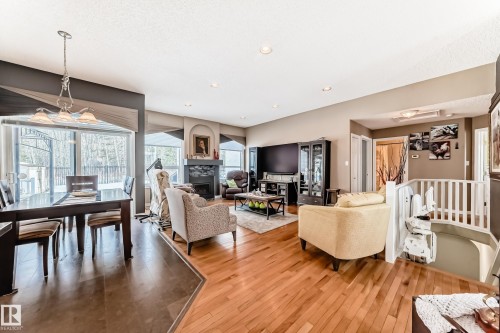 Living area featuring a glass covered fireplace and light wood-style flooring - 4 Harriott Court, St. Albert, AB - Indoor