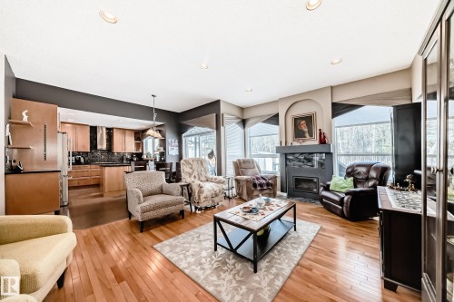 Living room with light wood-type flooring, a glass covered fireplace, healthy amount of natural light, and recessed lighting - 4 Harriott Court, St. Albert, AB - Indoor Photo Showing Living Room With Fireplace
