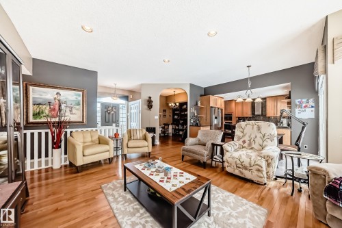 Living area featuring suspended lighting, light wood-style flooring, and arched walkways - 4 Harriott Court, St. Albert, AB - Indoor Photo Showing Living Room