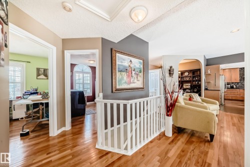 Hallway featuring a textured ceiling, light wood finished floors, and an office area - 4 Harriott Court, St. Albert, AB - Indoor