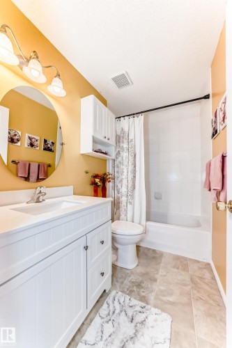 Bathroom with vanity, shower / bath combo, and light tile patterned floors - 4 Harriott Court, St. Albert, AB - Indoor Photo Showing Bathroom