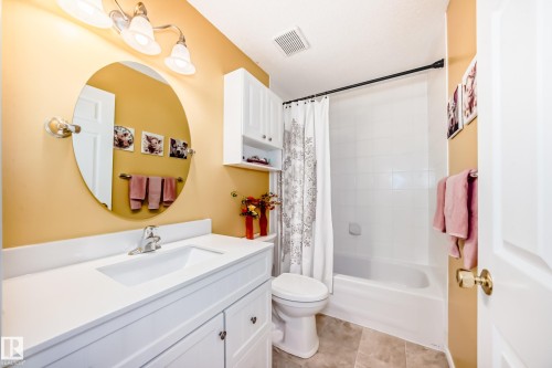 Bathroom featuring vanity, shower / tub combo with curtain, and light tile patterned floors - 4 Harriott Court, St. Albert, AB - Indoor Photo Showing Bathroom