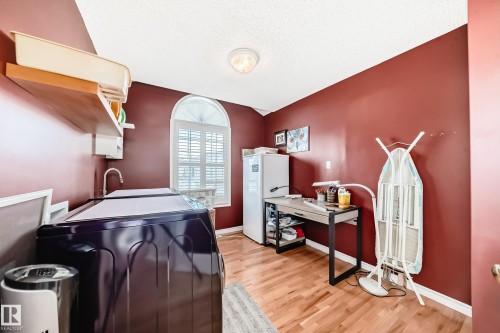 Laundry room featuring light wood-style floors, a textured ceiling, and washer and dryer - 4 Harriott Court, St. Albert, AB - Indoor Photo Showing Laundry Room