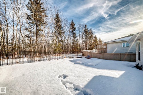 Yard covered in snow with a fenced backyard and a wooden deck - 4 Harriott Court, St. Albert, AB - Outdoor