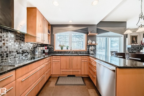 Kitchen featuring dark stone countertops, a peninsula, open shelves, dishwasher, and black electric cooktop - 4 Harriott Court, St. Albert, AB - Indoor Photo Showing Kitchen