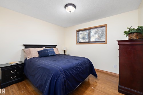 Bedroom featuring wood finished floors and a textured ceiling - 5703 143 Avenue, Edmonton, AB - Indoor Photo Showing Bedroom