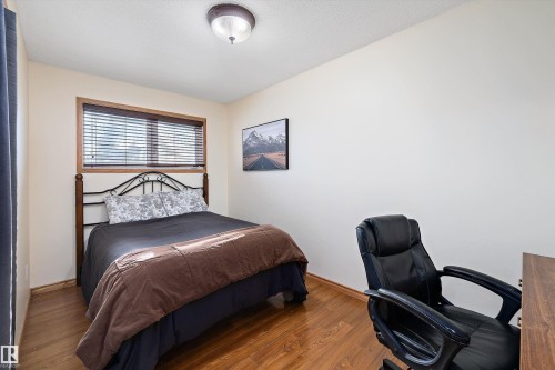Bedroom with wood finished floors and a desk - 5703 143 Avenue, Edmonton, AB - Indoor Photo Showing Bedroom