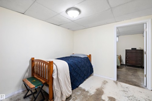 Bedroom featuring a paneled ceiling and concrete flooring - 5703 143 Avenue, Edmonton, AB - Indoor
