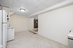 Finished basement featuring a drop ceiling and freestanding refrigerator - 