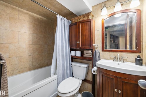 Bathroom with shower / bathtub combination with curtain, vanity, and tile walls - 5703 143 Avenue, Edmonton, AB - Indoor Photo Showing Bathroom
