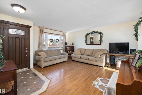 Living room with hardwood / wood-style flooring and a textured ceiling - 5703 143 Avenue, Edmonton, AB - Indoor Photo Showing Living Room