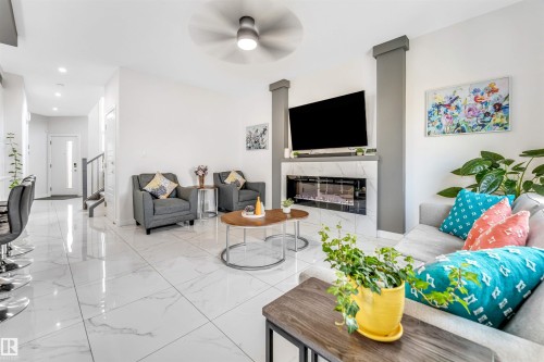 Living room featuring a fireplace, light marble finish floors, a ceiling fan, and recessed lighting - 1522 17 Avenue, Edmonton, AB - Indoor With Fireplace