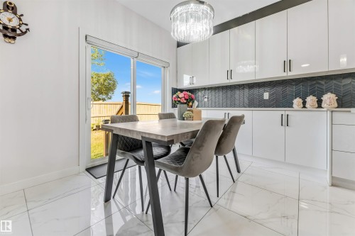Dining room featuring light marble finish floors and suspended lighting - 1522 17 Avenue, Edmonton, AB - Indoor Photo Showing Other Room