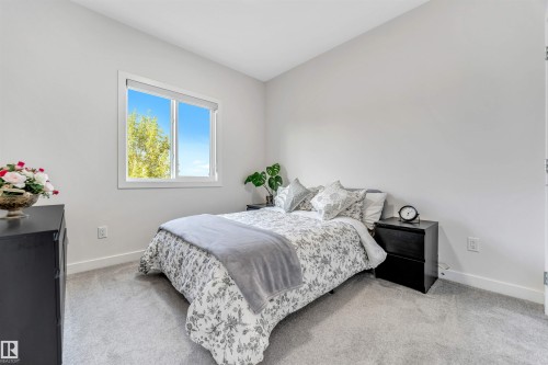 Bedroom with baseboards and light carpet - 1522 17 Avenue, Edmonton, AB - Indoor Photo Showing Bedroom