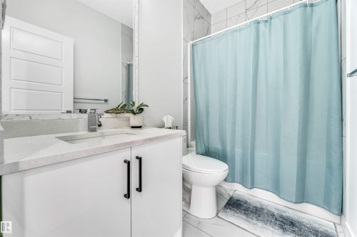 Full bathroom featuring vanity, light marble finish floors, and shower / tub combo with curtain - 1522 17 Avenue, Edmonton, AB - Indoor Photo Showing Bathroom