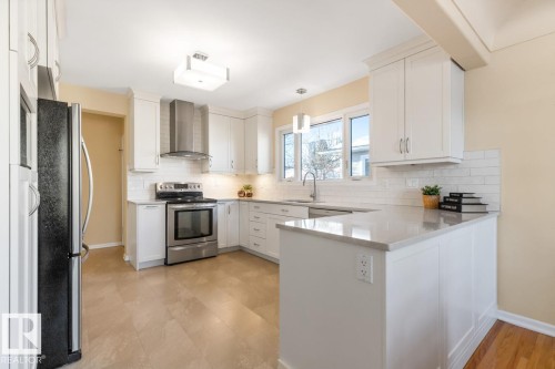 White kitchen with quartz counters and stainless steel appliances - 8707 Strathearn Drive, Edmonton, AB - Indoor Photo Showing Kitchen With Upgraded Kitchen