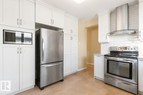 White kitchen with quartz counters and stainless steel appliances - 8707 Strathearn Drive, Edmonton, AB - Indoor Photo Showing Kitchen With Stainless Steel Kitchen
