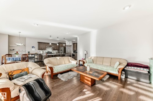 Living area featuring dark wood-style floors, recessed lighting, and beverage cooler - 7719 Getty Wynd, Edmonton, AB - Indoor Photo Showing Living Room
