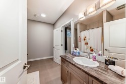 Full bathroom featuring a shower with curtain, vanity, and dark flooring - 