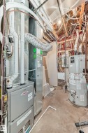 Utility room featuring gas water heater and heating unit - 