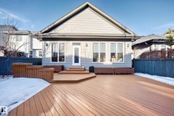 Snow covered rear of property featuring a deck - 