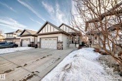 View of front facade featuring board and batten siding, concrete driveway, stone siding, and a garage - 