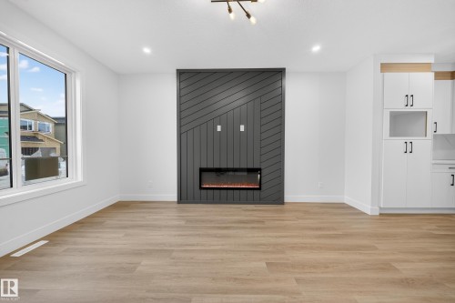 Unfurnished living room featuring light wood-style floors, a fireplace, and recessed lighting - 436 Crystal Creek Link, Leduc, AB - Indoor With Fireplace