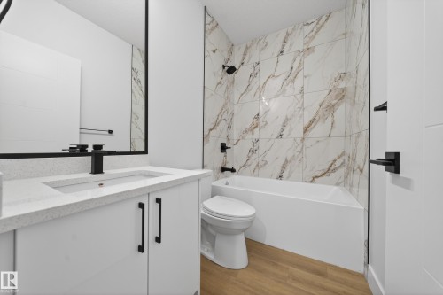 Full bath featuring vanity, tub / shower combination, and light wood-type flooring - 436 Crystal Creek Link, Leduc, AB - Indoor Photo Showing Bathroom