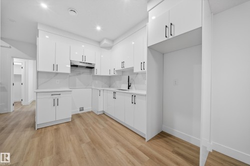Kitchen with white cabinetry, modern cabinets, backsplash, light wood-style flooring, and recessed lighting - 436 Crystal Creek Link, Leduc, AB - Indoor Photo Showing Kitchen