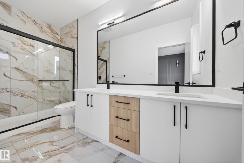Full bath featuring a marble finish shower, double vanity, and light marble finish flooring - 436 Crystal Creek Link, Leduc, AB - Indoor Photo Showing Bathroom