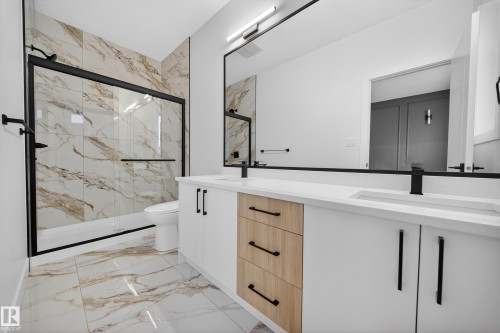 Full bathroom with a marble finish shower, double vanity, and light marble finish flooring - 436 Crystal Creek Link, Leduc, AB - Indoor