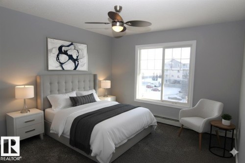 Bedroom with a baseboard heating unit, ceiling fan, and dark carpet - 404 4407 23 Street, Edmonton, AB - Indoor Photo Showing Bedroom
