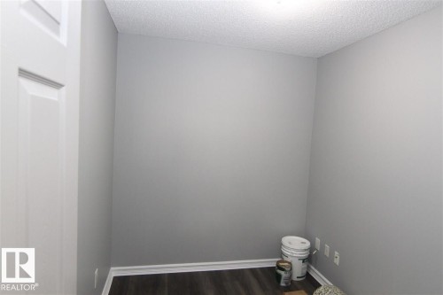 Spare room featuring dark wood-style floors and a textured ceiling - 404 4407 23 Street, Edmonton, AB - Indoor Photo Showing Other Room