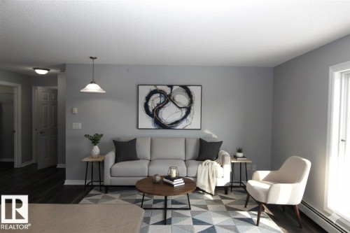 Living area featuring a baseboard radiator and wood finished floors - 404 4407 23 Street, Edmonton, AB - Indoor Photo Showing Living Room