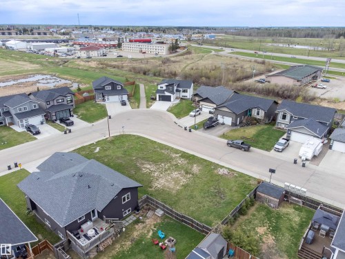 Aerial view of a residential development featuring single-family homes and undeveloped lots - 4930 57 Avenue, Cold Lake, AB 