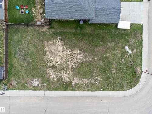 Expansive corner lot featuring a paved street, concrete sidewalk, and established fencing - 4930 57 Avenue, Cold Lake, AB 