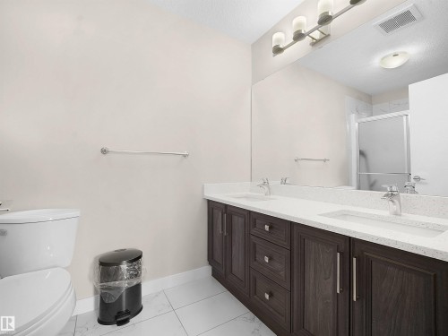 Full bath with a shower stall, double vanity, and a textured ceiling - 5423 Chappelle Road, Edmonton, AB - Indoor Photo Showing Bathroom