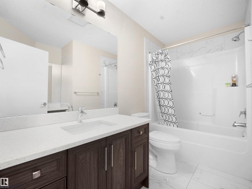 Bathroom featuring vanity, shower / bath combination with curtain, and a textured ceiling - 5423 Chappelle Road, Edmonton, AB - Indoor Photo Showing Bathroom