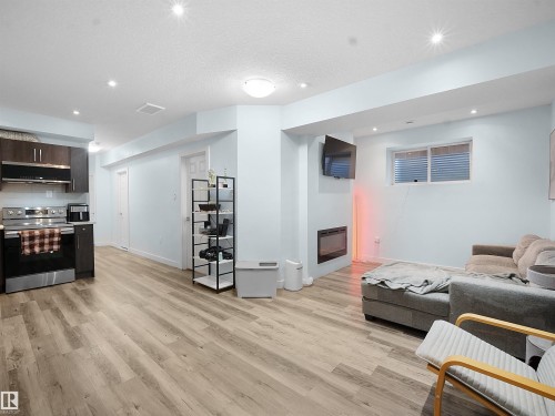 Living area featuring a glass covered fireplace, light wood-style floors, recessed lighting, and a textured ceiling - 5423 Chappelle Road, Edmonton, AB - Indoor