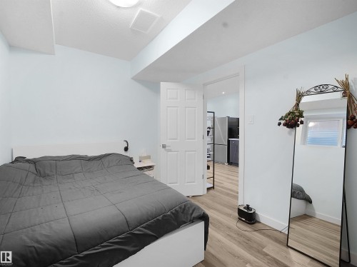 Bedroom with light wood-style floors and freestanding refrigerator - 5423 Chappelle Road, Edmonton, AB - Indoor Photo Showing Bedroom