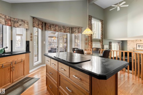 Kitchen with a kitchen island, vaulted ceiling, wood finish cabinets, light wood-style floors, and a ceiling fan - 519 Buchanan Road, Edmonton, AB - Indoor Photo Showing Kitchen