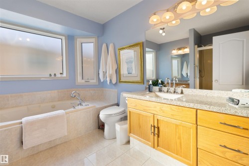 Bathroom featuring vanity, light tile patterned flooring, a garden tub, and a shower with shower door - 519 Buchanan Road, Edmonton, AB - Indoor Photo Showing Bathroom