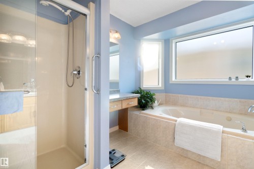 Bathroom with a bath, a stall shower, vanity, and light tile patterned floors - 519 Buchanan Road, Edmonton, AB - Indoor Photo Showing Bathroom