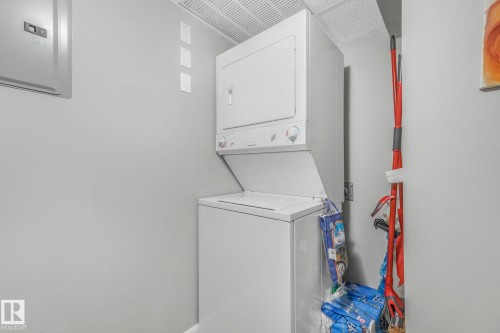 Washroom with electric panel and stacked washer / drying machine - 415 530 Hooke Road, Edmonton, AB - Indoor Photo Showing Laundry Room