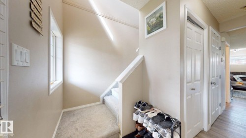 Stairs featuring carpet floors and a textured ceiling - 1150 37B Avenue, Edmonton, AB - Indoor Photo Showing Other Room