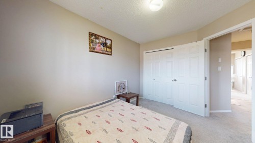 Bedroom with a textured ceiling, light carpet, and a closet - 1150 37B Avenue, Edmonton, AB - Indoor Photo Showing Bedroom