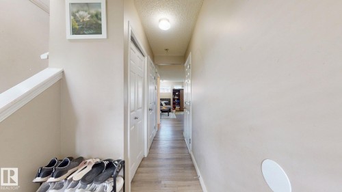 Hallway featuring a textured ceiling and light wood finished floors - 1150 37B Avenue, Edmonton, AB - Indoor Photo Showing Other Room