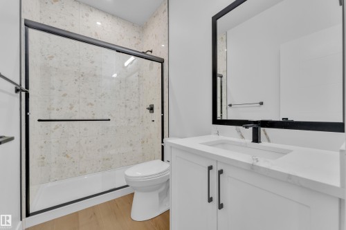 Bathroom with vanity, a stall shower, and light wood finished floors - 202 Basin Court, Leduc, AB - Indoor Photo Showing Bathroom